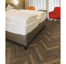 Schlafzimmer mit Doppelbett und Fischgrätenparkett