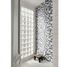 Badezimmer mit Glasbausteinwand und geometrisch gemusterter Fliesenwand