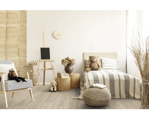 Helles Kinderzimmer mit Bett, Sessel, Staffelei und Holzfußboden