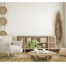 Wohnzimmer mit Sessel, Anrichte und Dekoration in hellem, freundlichem Design