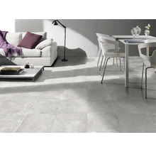 Heller Wohnraum mit Couch, Tisch, Stuhl und Bodenfliesen