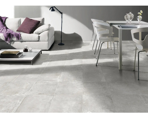 Heller Wohnraum mit Couch, Tisch, Stuhl und Bodenfliesen