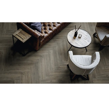 Wohnzimmer mit braunem Ledersofa, Holztisch und Boden im Fischgrätmuster