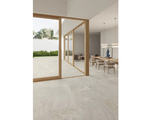 Heller Raum mit Terrassenfliesen, Esstisch und Zugang zum Garten