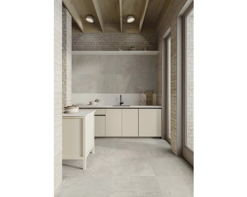 Helle Küche mit Fliesenboden, weißen Schränken und Backsteinwand