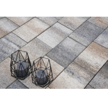 Verlegung von Pflastersteinen mit zwei dekorativen Windlichtern