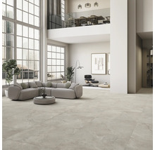 Geräumiges Wohnzimmer mit Fliesenboden, Ecksofa und grossen Fenstern