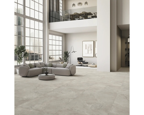 Geräumiges Wohnzimmer mit Fliesenboden, Ecksofa und grossen Fenstern