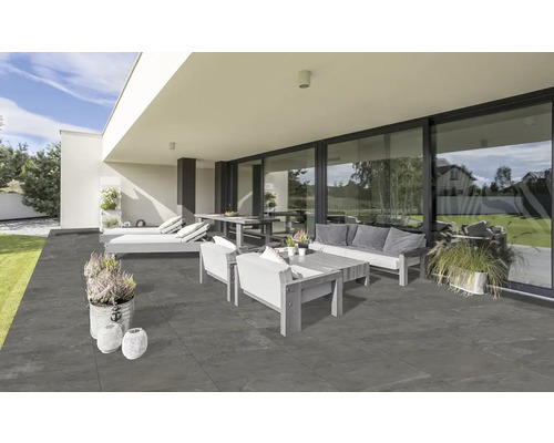 Moderne Terrasse mit grauen Steinzeugfliesen, Gartenmöbeln und Pflanzgefäßen für einen stilvollen Außenbereich.