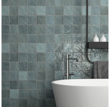 Modernes Badezimmer mit bläulichen Wandfliesen, Badewanne und Armatur.