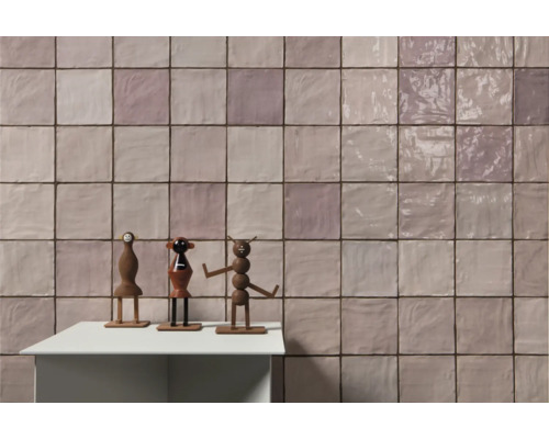 Fliesenwand mit Spielzeugfiguren auf einem Tisch