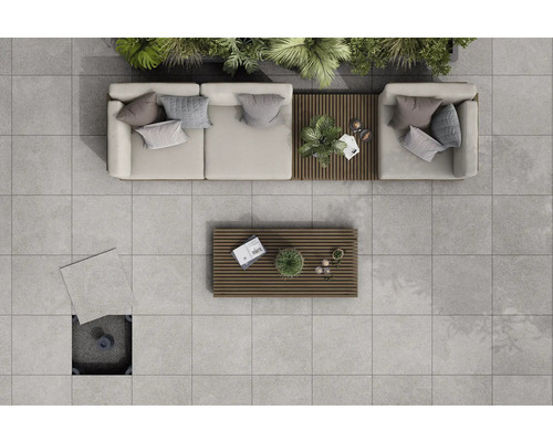 Draufsicht einer Terrasse mit hellgrauen Terrassenplatten, Loungemöbeln und Holztischen