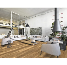 Heller Wohnraum mit Holzboden, weißen Sofas, Sesseln und Kamin