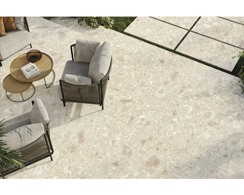 Terrasse mit Outdoor-Sitzmöbeln und Bodenfliesen in Natursteinoptik