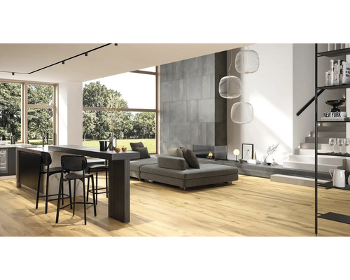 Helles Wohnzimmer mit Holzboden, grauer Couch, Küchenbar und Treppe