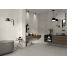 Helles Badezimmer mit Badewanne, Waschtisch und grauen Fliesen