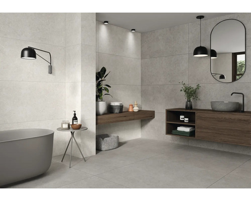 Helles Badezimmer mit Badewanne, Waschtisch und grauen Fliesen