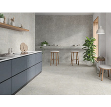 Heller Raum mit Fliesenboden, Küchenzeile und Hockern