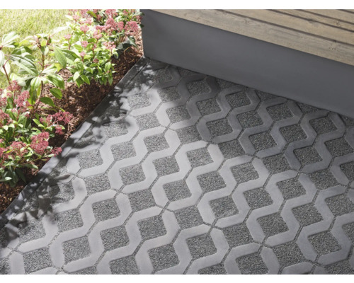 Verlegte graue Rasengittersteine auf einer Terrasse mit Bepflanzung