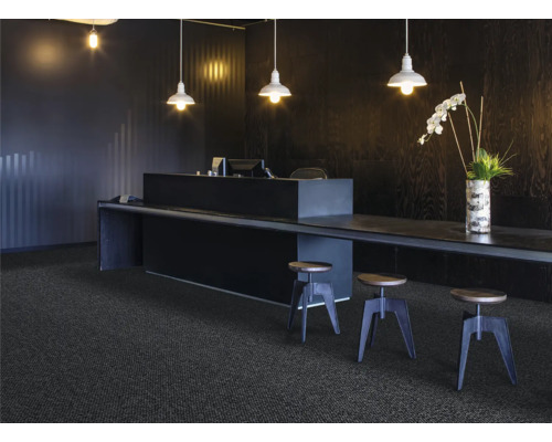 Szene mit dunklem Teppichboden, Tresen, Hockern und Beleuchtung für ein modernes Büroambiente.