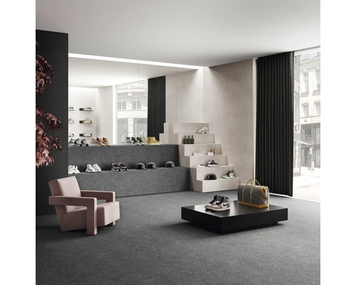 Geräumiger Verkaufsraum mit Schuhen, Sesseln und dekorativer Treppe