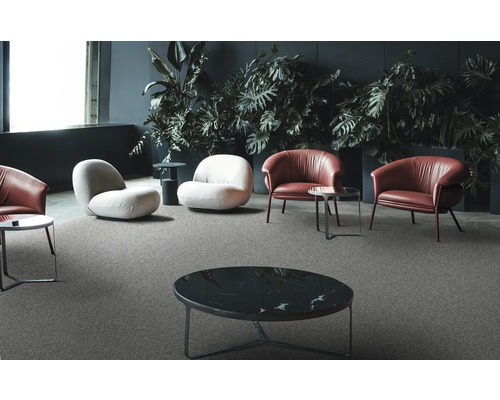 Helle und dunkle Sessel mit Tischen auf einem grauen Teppichboden in einem Wohnzimmer