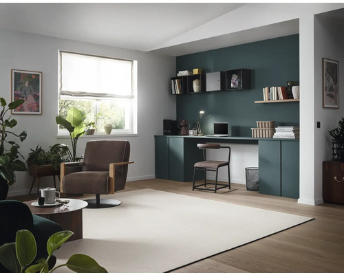 Helles Wohnzimmer mit Arbeitsbereich, Sessel und Pflanzen