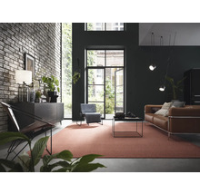Wohnzimmer mit Backsteinwand, Kommode, Sessel, Sofa und Teppich