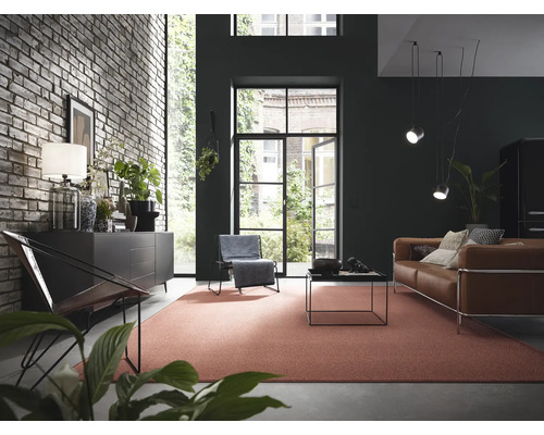 Wohnzimmer mit Backsteinwand, Kommode, Sessel, Sofa und Teppich