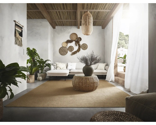 Wohnzimmer mit Sofa, Teppich, Zimmerpflanzen und dekorativen Wandelementen im natürlichen Design