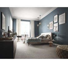 Schlafzimmer mit Bett, Kommode und Teppichboden in harmonischer Gestaltung