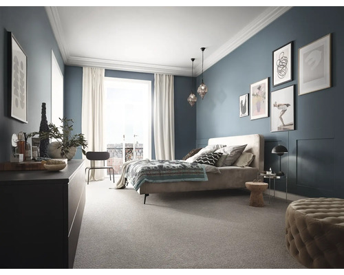 Schlafzimmer mit Bett, Kommode und Teppichboden in harmonischer Gestaltung