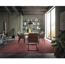 Esszimmer mit Holztisch, Stühlen, rotem Teppich und Boxsack für ein loftartiges Ambiente