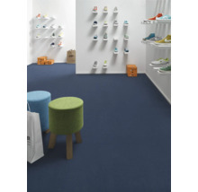 Innenraumansicht eines Schuhgeschäfts mit blauer Auslegware, kleinen Hockern und Schuhen an den Wänden