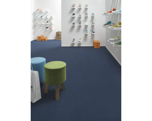 Innenraumansicht eines Schuhgeschäfts mit blauer Auslegware, kleinen Hockern und Schuhen an den Wänden