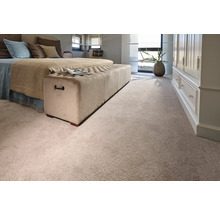 Schlafzimmer mit Bett, Polsterbank und Teppichboden.