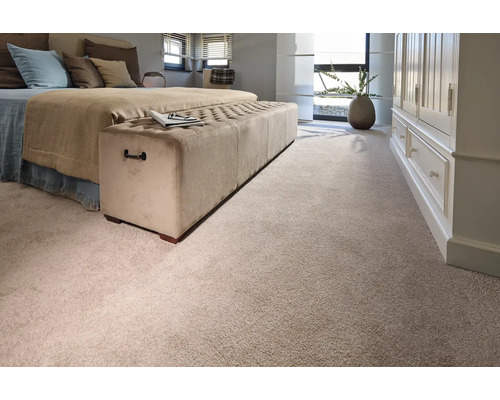 Schlafzimmer mit Bett, Polsterbank und Teppichboden.