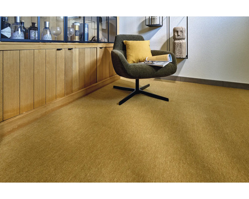 Innenaufnahme eines Raumes mit Teppichboden, einem Sessel und einer Anrichte