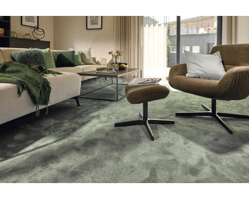 Wohnzimmer mit Sofa, Sessel und grünem Teppich