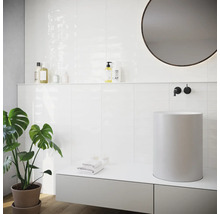 Helles Badezimmer mit weißen Fliesen, Aufsatzwaschbecken und runden Spiegel