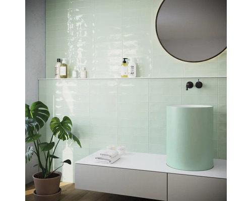 Modernes Badezimmer mit mintgrünen Fliesen, Aufsatzwaschbecken und runden Spiegel