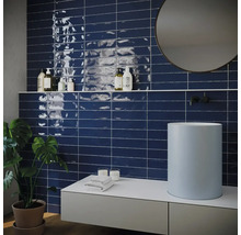 Badezimmer mit Waschtisch, Spiegel und Wandfliesen