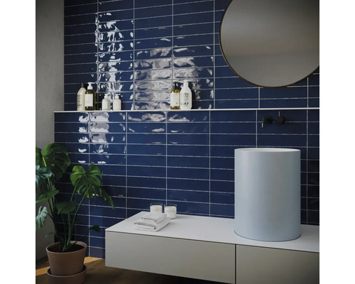 Badezimmer mit Waschtisch, Spiegel und Wandfliesen