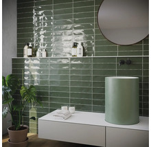 Badezimmer mit grünen Fliesen, Waschbecken und Spiegel