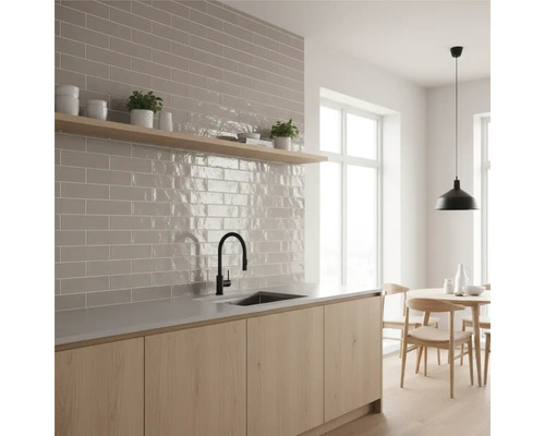 Helle Küche mit Fliesenspiegel im Backsteinformat, hölzerner Arbeitsplatte und Esstisch