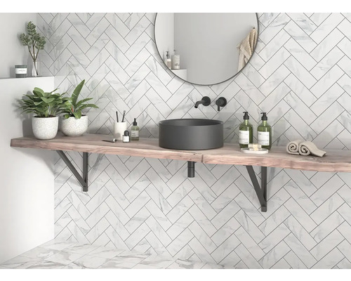 Helles Badezimmer mit Marmorfliesen im Fischgrätmuster, Waschtisch mit Aufsatzwaschbecken und rundem Spiegel