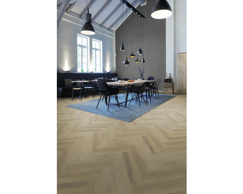 Hellbrauner Boden in Fischgrät-Optik in modernem Esszimmer mit Industrie-Leuchten, blauem Teppich und Holztisch.