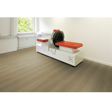 Vinylboden in Holzoptik verlegt in einem hellen Behandlungsraum mit medizinischem Gerät für Physiotherapie.