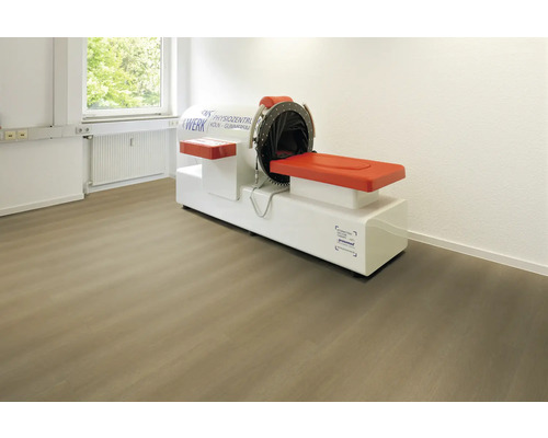 Vinylboden in Holzoptik verlegt in einem hellen Behandlungsraum mit medizinischem Gerät für Physiotherapie.