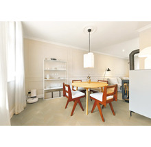 Helles, organisiertes Esszimmer mit rundem Holztisch, Stühlen mit weißen Polstern, weißem Regal und Wandgestaltung mit Zierleisten.
